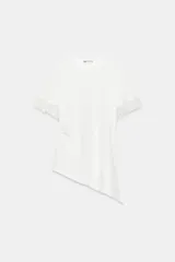 Camiseta blanca de algodón con cuello redondo, manga corta con detalles de encaje a tono y bajo asimétrico.