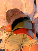 Set de tres gorras de cuero con viseras de diferentes colores: marrón oscuro, verde oliva y rojo ladrillo. La gorra superior tiene un bordado sutil en hilo claro.