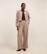 Blusa color beige de mangas cortas, confeccionada en tejido rib con textura acanalada y cuello redondo.