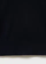 Jersey de punto fino color negro, con cuello en pico y manga larga. Presenta un diseño recto y minimalista.