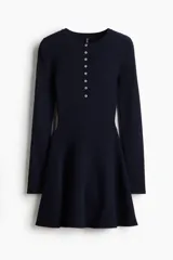 Vestido corto de punto acanalado en color azul marino, con escote redondo, tapeta de botones frontal, mangas largas, cuerpo entallado y falda con vuelo.