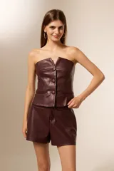 Top strapless de eco-cuero negro, con pinzas y botones frontales.