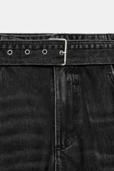Pantalón cargo de tiro medio confeccionado en denim marrón oscuro. Presenta bolsillos laterales con solapa, bolsillos clásicos y un cinturón integrado del mismo tejido con hebilla metálica.