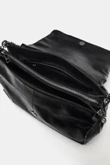 Bolso de hombro con solapa, confeccionado en material sintético con acabado brillante y efecto envejecido. Presenta un diseño estructurado con costuras decorativas, tres compartimentos internos, uno de ellos con cierre de cremallera, y asa de cadena metálica. Se cierra mediante un imán oculto.