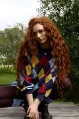 Buzo de tejido de punto con diseño de rombos en colores azul marino, amarillo, celeste y rojo. Presenta cuello redondo a la base, corte oversized y puños acanalados.