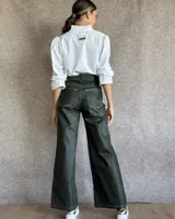 Pantalón de jean estilo wide leg con costuras verticales frontales, tiro alto y bolsillos laterales.