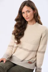 Buzo tejido de punto con diseño de rayas horizontales en tonos crema, gris y rosa. Presenta cuello redondo, mangas largas y puños acanalados, con un pequeño aplique de cuero sintético en el ruedo.