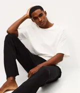 Pantalón de pijama masculino de corte recto, confeccionado en tejido de modal, poliéster y elastano. Presenta un diseño liso con cintura elástica y cordón ajustable para mayor comodidad.