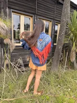 Camisa de jean con diseño estilo western, featuring un canesú trasero con estampado paisley en blanco y azul, y flecos largos de cuero rojo. Cuenta con mangas largas abullonadas con puños elásticos fruncidos.