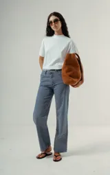 Camiseta blanca de algodón orgánico con cuello redondo alto y mangas cortas dobladas. Presenta un pequeño logo bordado en el pecho.