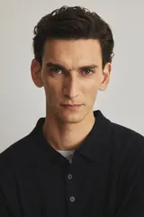 Remera polo de manga larga confeccionada en tejido de punto de lana merino, con cuello clásico, tapeta de botones frontal y terminaciones acanaladas en puños y cintura.