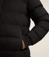 Campera puffer deportiva Get Over, color negro, con capucha, cierre frontal por cremallera y puños elásticos. Diseño acolchado sin costuras visibles.