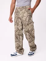 Pantalon recto de lona, color beige, con diseño de paneles reforzados en las piernas y cierre frontal con boton.