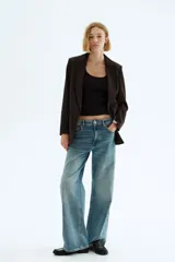 Blazer de sarga con solapas de pico, diseño de frente abierto y bolsillos delanteros con solapa. Presenta mangas con forro a rayas diseñado para ser remangado.