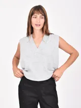 Chaleco de tejido de punto color gris claro, sin mangas, con escote en V profundo y cuello acanalado.