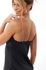 Vestido corto negro de satén con escote en V y tirantes finos de strass.