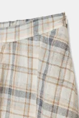 Falda midi de tiro alto con estampado a cuadros en tonos beige, blanco, gris y marrón. El bajo es asimétrico y está acabado con un borde de encaje blanco a tono.