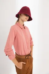 Pantalón de gamuza color marrón, de tiro medio y corte slouchy. Presenta bolsillos laterales y traseros, cierre metálico frontal y forro interno con stretch.