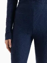 Pantalon de corte oxford en color azul marino, con textura jacquard en relieve y diseño ajustado en la parte superior con botamangas acampanadas.