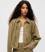 Campera bomber de jean color verde oliva, de corte holgado y diseño corto. Cuenta con cuello polo, mangas largas y cierre frontal con botones.