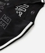 Camisa deportiva de estilo béisbol confeccionada en tejido mesh negro. Presenta cuello en V, cierre frontal con botones a presión, mangas cortas con franjas laterales blancas y bordado con la palabra Breaker y el número 96 en el frente.