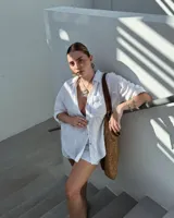 Collar artesanal con dije central de metal con textura orgánica irregular que evoca una ostra. El dije está montado sobre un cordón de algodón natural, permitiendo un uso versátil y regulable.