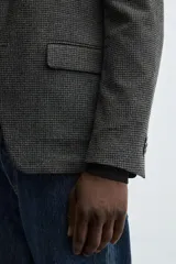 Blazer slim fit de estructura con diseño de pata de gallo, cuello con solapas de muesca, manga larga con botones en puños, bolsillos de solapa en cadera y cierre frontal con botones.