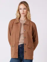 Sobrecamisa color marrón con cuello solapa de pana y cierre frontal con botones. Presenta bolsillos en la parte delantera.