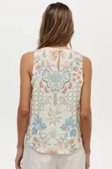 Musculosa de lino y viscosa, de color crudo con estampado multicolor de inspiración veraniega con flores, soles y motivos marinos. Presenta escote redondo y diseño sin mangas.