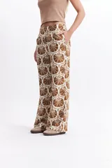 Pantalón wide leg estampado con diseño de conchas marinas en tonos verde oscuro y blanco. Presenta un calce relajado y cintura media.