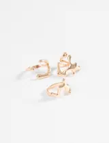 Set de tres anillos dorados con diseños irregulares y abstractos.