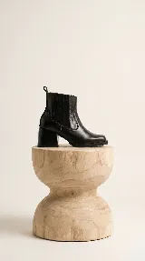 Bota corta de cuero negro con paneles laterales elásticos y taco cuadrado foliado en madera.