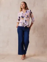 Blusa estampada de Zac & Rachel con cuello a la base, escote en V y botones. Tiene un bolsillo aplicado en la parte delantera, mangas largas regulables con presilla y botón, y terminación anudada opcional.