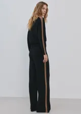 Pantalón de punto negro, de corte ancho y relajado, confeccionado con mezcla de acrílico, poliéster, poliamida y lana.