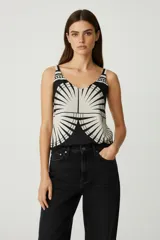 Top de viscosa ajustado al cuerpo, con escote profundo en V y detalle de argolla metálica en el centro del busto. Presenta un estampado geométrico en blanco y negro.