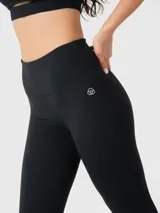 Calza negra de tiro alto con largo hasta el tobillo, confeccionada en tejido suave con tecnología Aloe Vera. Presenta un logo discreto en la parte superior del muslo.