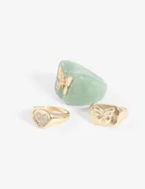 Set de tres anillos plateados, uno de plástico verde con una mariposa plateada, otro con forma de sello con una mariposa plateada y otro con forma de sello con un corazón plateado.