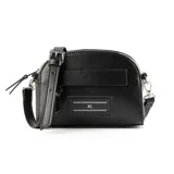Bandolera de tamaño pequeño en color negro, confeccionada en material sintético con acabado liso. Presenta un diseño de silueta redondeada con cierre superior, correa ajustable y un aplique decorativo frontal con el logo de la marca.