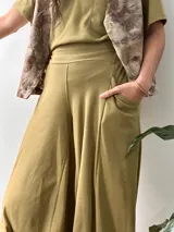 Conjunto compuesto por una remera de cuello redondo y un pantalón tipo balloon de tiro alto con puños elásticos en los tobillos y bolsillos laterales. Ambas prendas están confeccionadas en rib de algodón color verde oliva.