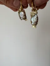 Aros tipo argolla con dije de bronce reticulado de forma irregular y piedra engarzada en el centro. Diseño artesanal con acabado texturizado.
