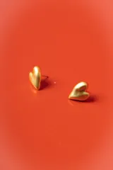Aros tipo abridor con diseño de corazón en acabado mate dorado.