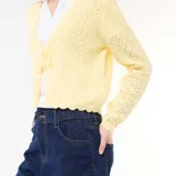 Chaqueta de punto con textura de croché en color amarillo pastel, con diseño de cuello en V, cierre frontal con lazada y terminaciones festoneadas en mangas y ruedo.