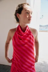 Top satinado sin mangas con cuello halter y estampado de rayas diagonales en tonos rojo y rosado.