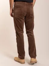 Pantalón de corte regular confeccionado en pana color marrón, con cierre de botón y cremallera, y bolsillos laterales y traseros.