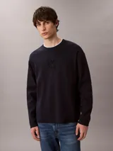Sweater de punto color azul marino, de manga larga, con cuello redondo y logo institucional en relieve al tono en el pecho.