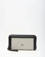 Billetera tipo fichero XL Extra Large, color negro y blanco con diseño texturizado, cierre perimetral y correa de mano. Incluye el logo de la marca en metal plateado en el centro.