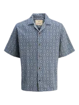 Camisa de manga corta con estampado geométrico en tonos azul y beige, cuello resort y cierre de botones. Confeccionada en tejido dobby 100% algodón.