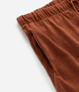Bermuda masculina de tejido jacquard color terracota, con cintura elástica, cordón de ajuste y detalle de rayas horizontales en el ruedo.