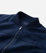 Chaqueta bomber de Marfinno en color tostado, con cierre frontal y cuello de tejido acanalado. Presenta un diseño liso con costuras horizontales y bolsillos funcionales.