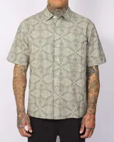 Camisa de manga corta color verde con estampado geométrico, cierre frontal con botones y un bolsillo en el pecho.